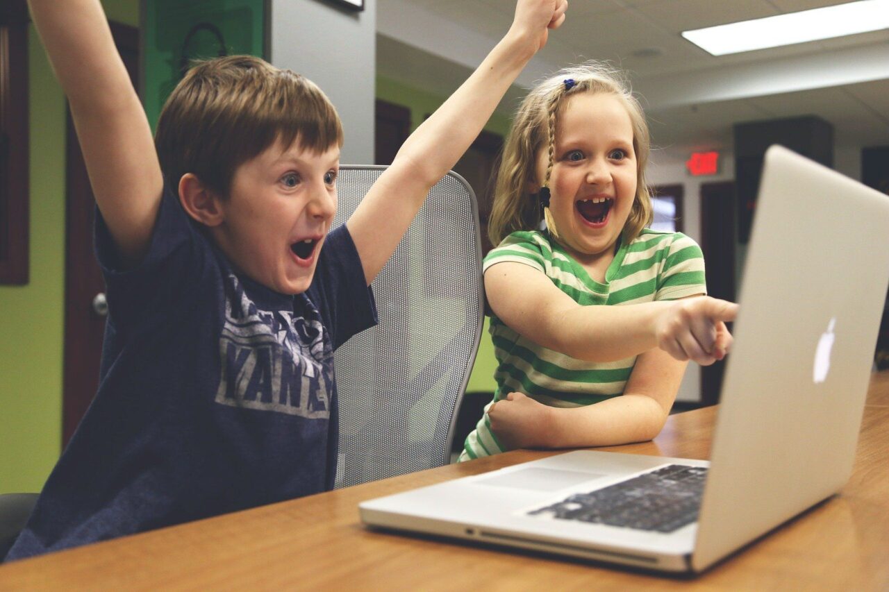 Zwei Kinder sitzen vor einem Laptop