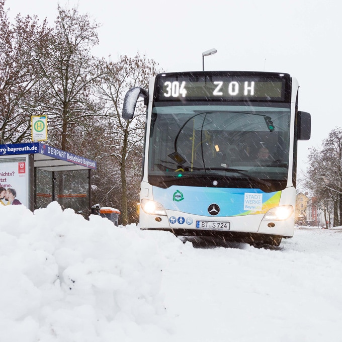 Stadtbus auf schneebedeckter Straße.