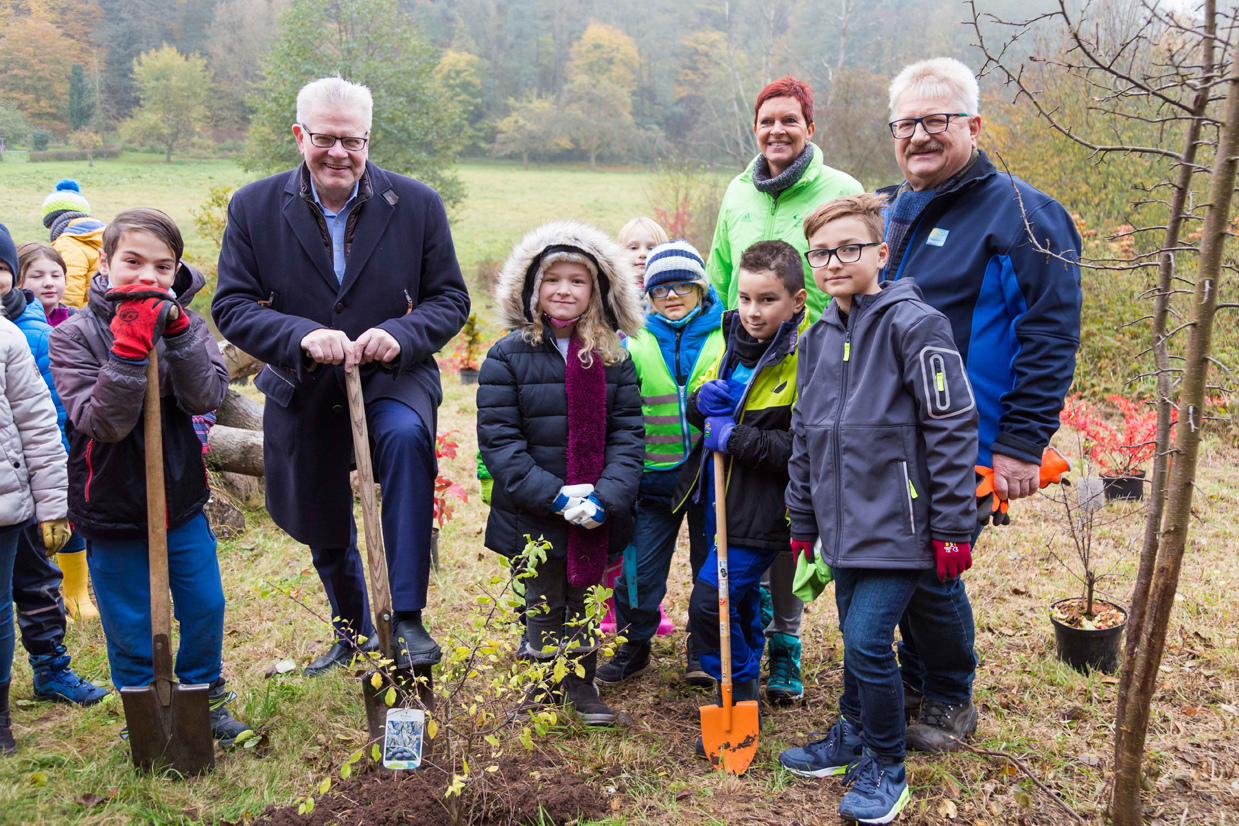 Junge Schüler und Oberbürgermeister Ebersberger mit Spaten auf einem Pflanzgrundstück.