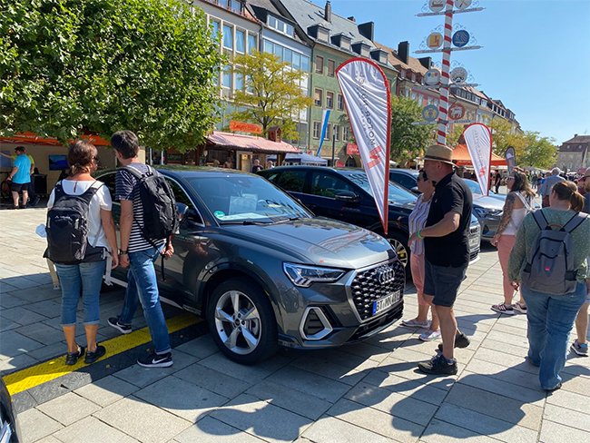 Mehrere Fahrzeuge stehen , die von Menschen angeschaut werden