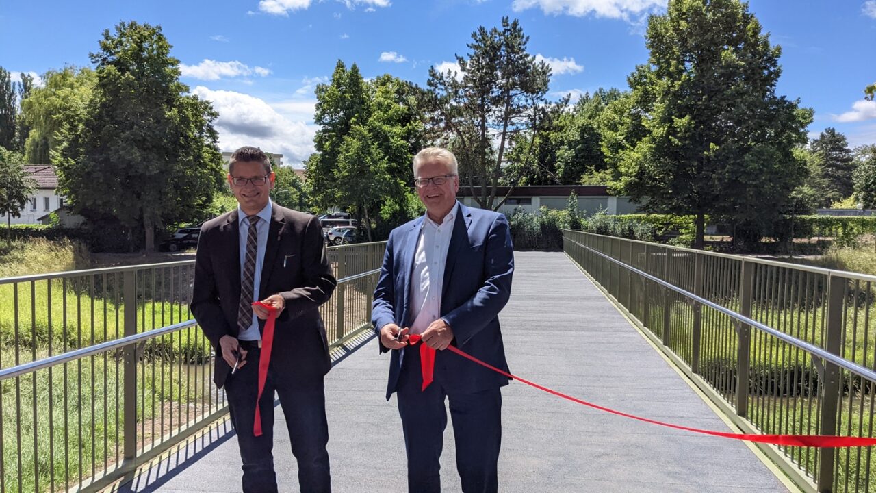 Alexander Lauer und Oberbürgermeister Thomas Ebersberger durchschneiden ein rotes Band zur Verkehrsfreigabe.