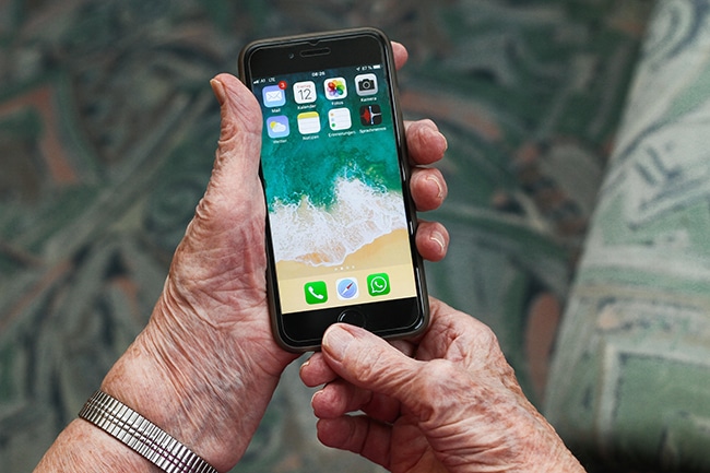 Seniorin hält ein Handy in der Hand