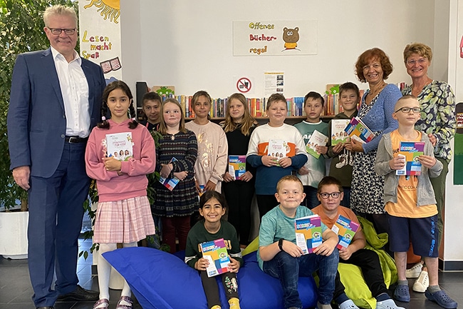 Oberbürgermeister Thomas Ebersberger (links) und Siglinde Seidler-Rieß (2. von rechts) übergaben die Hausaufgabenhefte an die Schüler/innen der 4a und an Schulleiterin Anita Strohhacker (rechts).