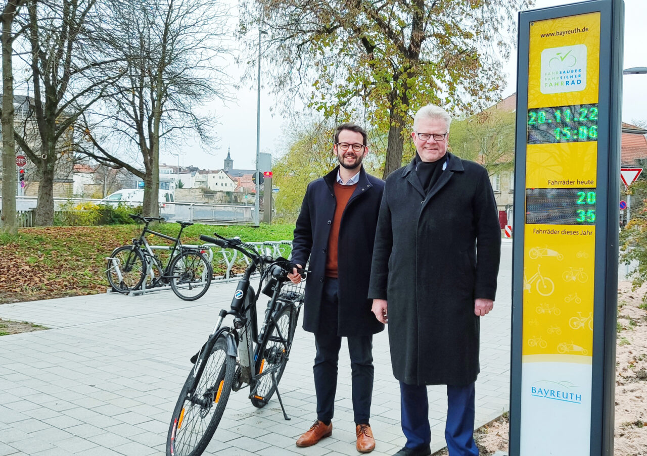 OB Ebersberger und Bürgermeister Zippel mit Rad vor der gelben Radzählsäule.