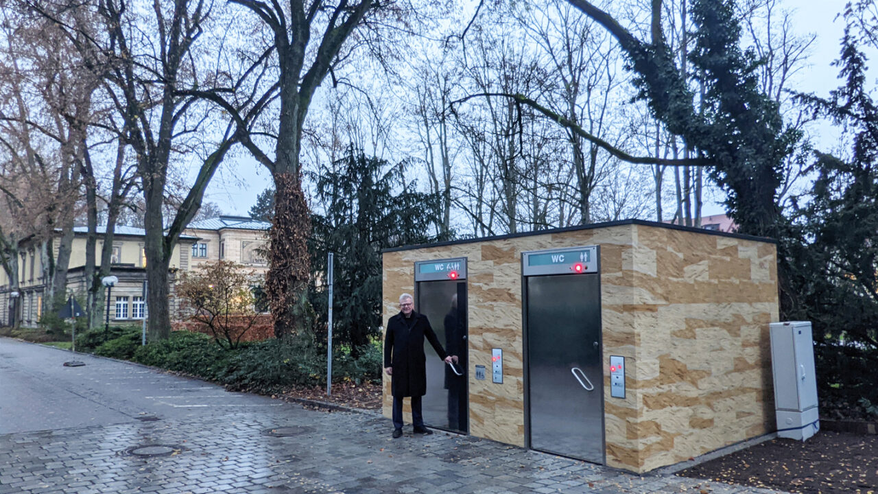 OB Ebersberger steht vor der Eingangstür der WC-Anlage.