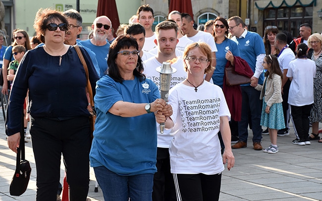 Zwei Menschen tragen die Fackel