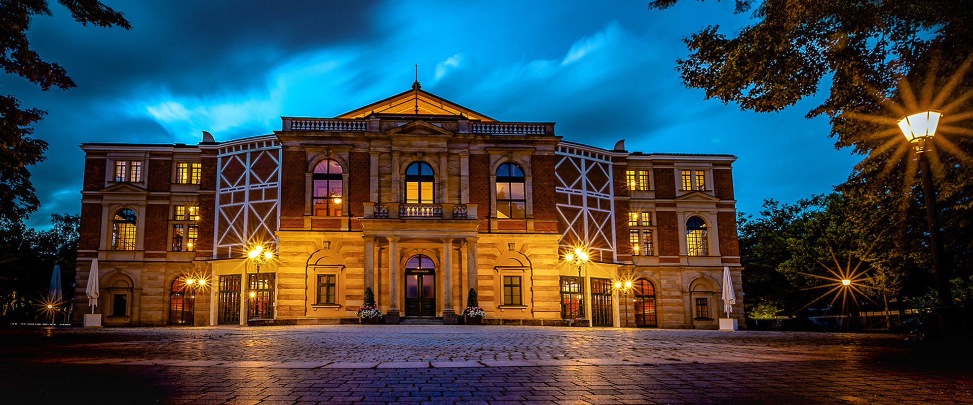 Das Bayreuther Festspielhaus beleuchted zur Abenddämmerung