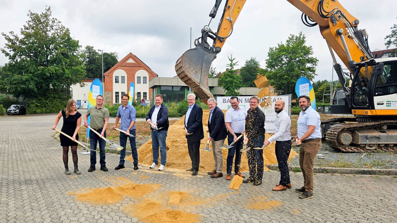 Spatenstich für ein neues Schaltwerk. Mehrere Männer halten Schaufeln in der Hand und stehen vor einem Bagger. | Foto: Stadtwerke Bayreuth