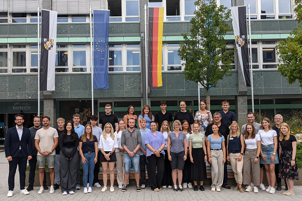 Die Auszubildenden stehen zu einem Gruppenfoto vor dem Rathaus