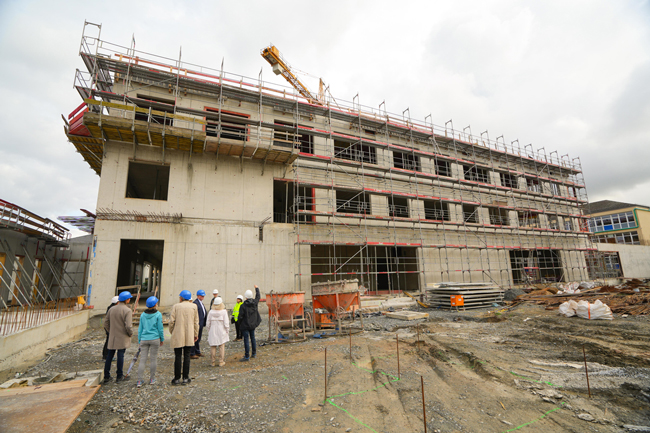 Der Lenkungskreis für den Neubau der Staatlichen Berufsschule besucht die Baustelle.