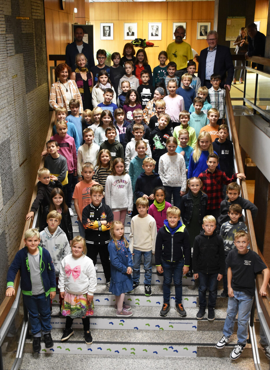 Die Kinder stehen auf einer Treppe hintereinander aufgereiht