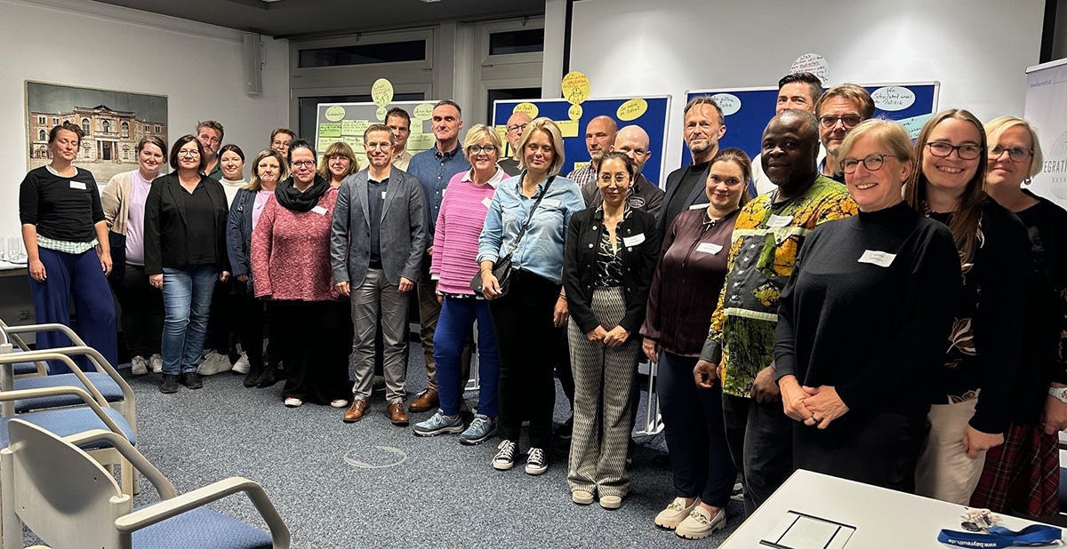 Mehrere Menschen stehen nebeneinander und lächeln in die Fotokamera