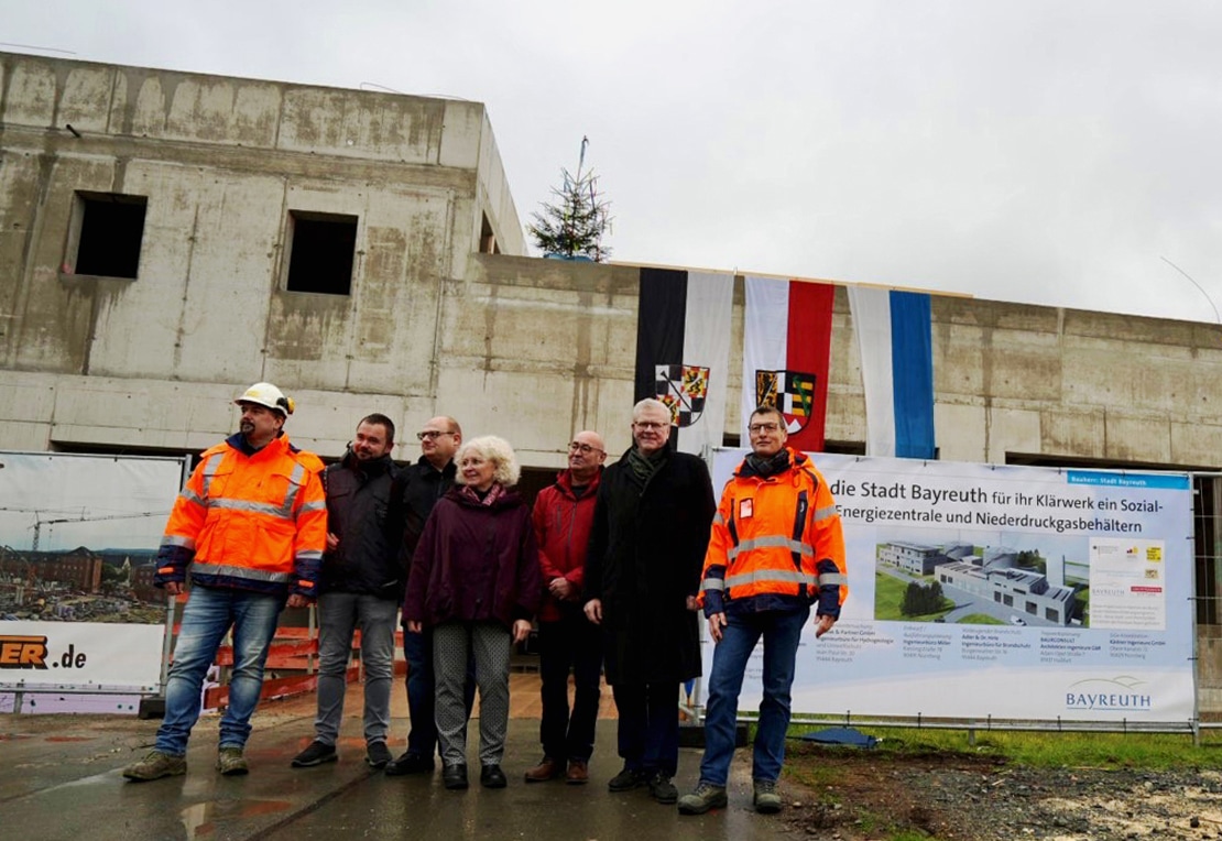 Eine Personengruppe steht vor dem Rohbau eines Gebäudes. | Foto: Stadt Bayreuth