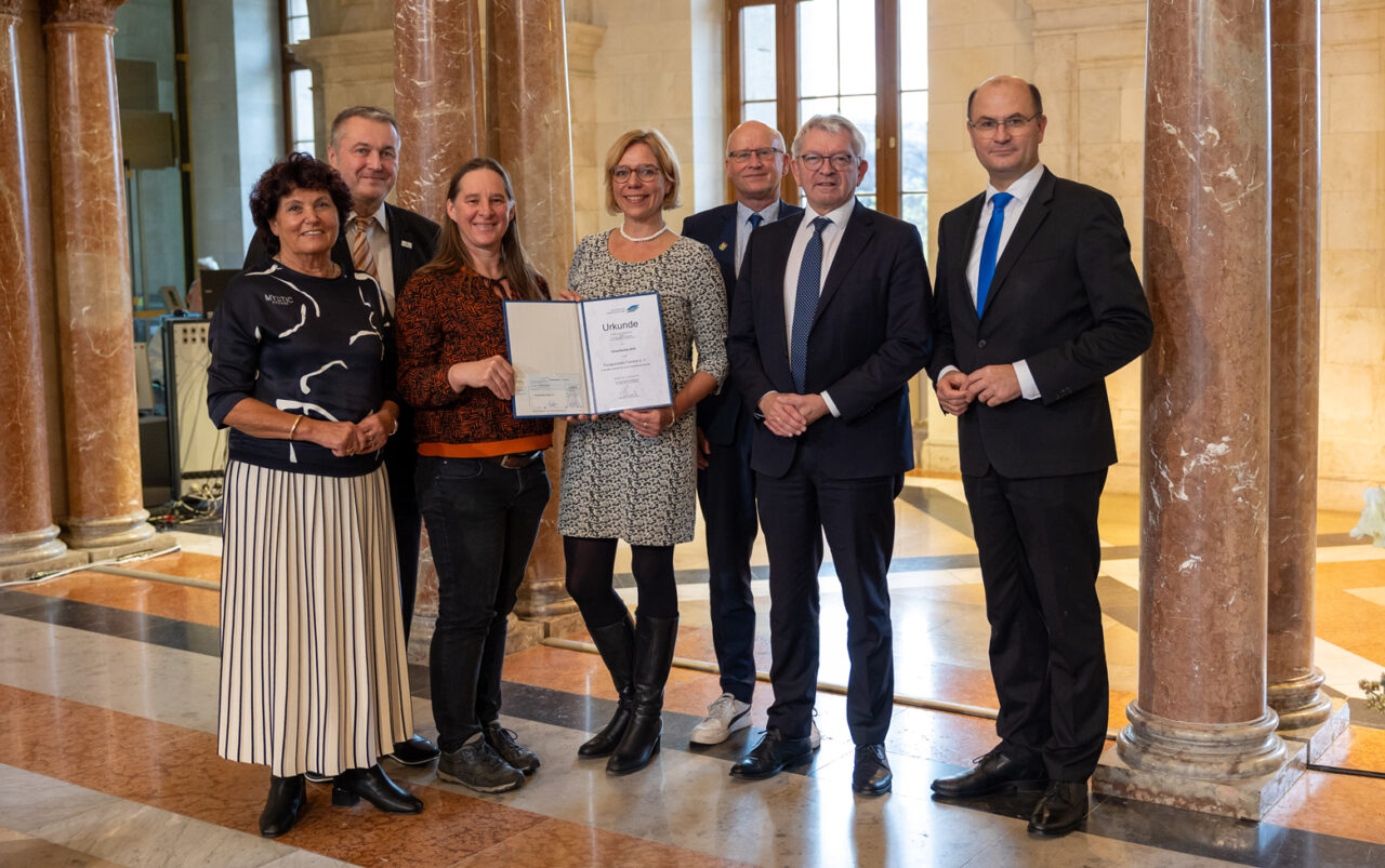 Preisverleihung in der Staatskanzlei in München (von links): Ingrid Heckner (Vorsitzende des Vorstands der Bayerischen Landesstiftung), Klaus Bauer (Stellvertretender Landrat des Landkreises Bayreuth), Anne Schmitt (Geschäftsführerin Flussparadies Franken), Eva Rundholz (Stadt Bayreuth, Regionalmanagerin), Stefan Paulus (Bürgermeister der Gemeinde Knetzgau), Johann Kalb (Landrat Landkreis Bamberg), Staatsminister Albert Füracker. | Foto: StMFH/Christian Blaschka