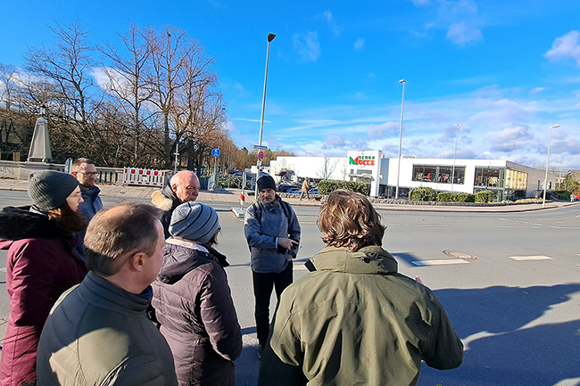 Menschen stehen an der Straße und blicken auf die Kreuzung