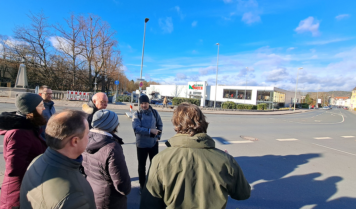 Menschen stehen an der Straße und blicken auf die Kreuzung