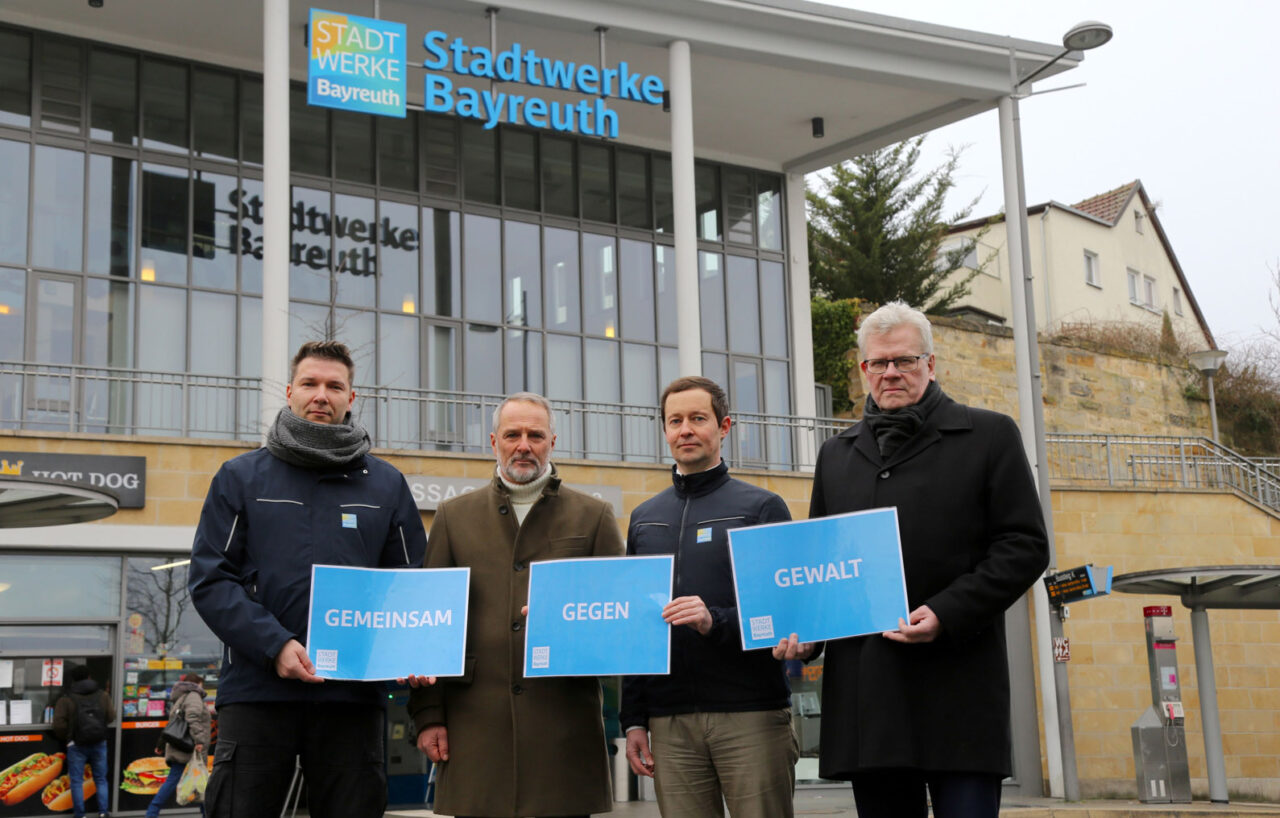 Vier Männer halten Schilder mit der Aufschrift "Gemeinsam gegen Gewalt" hoch. | Foto: Stadtwerke Bayreuth