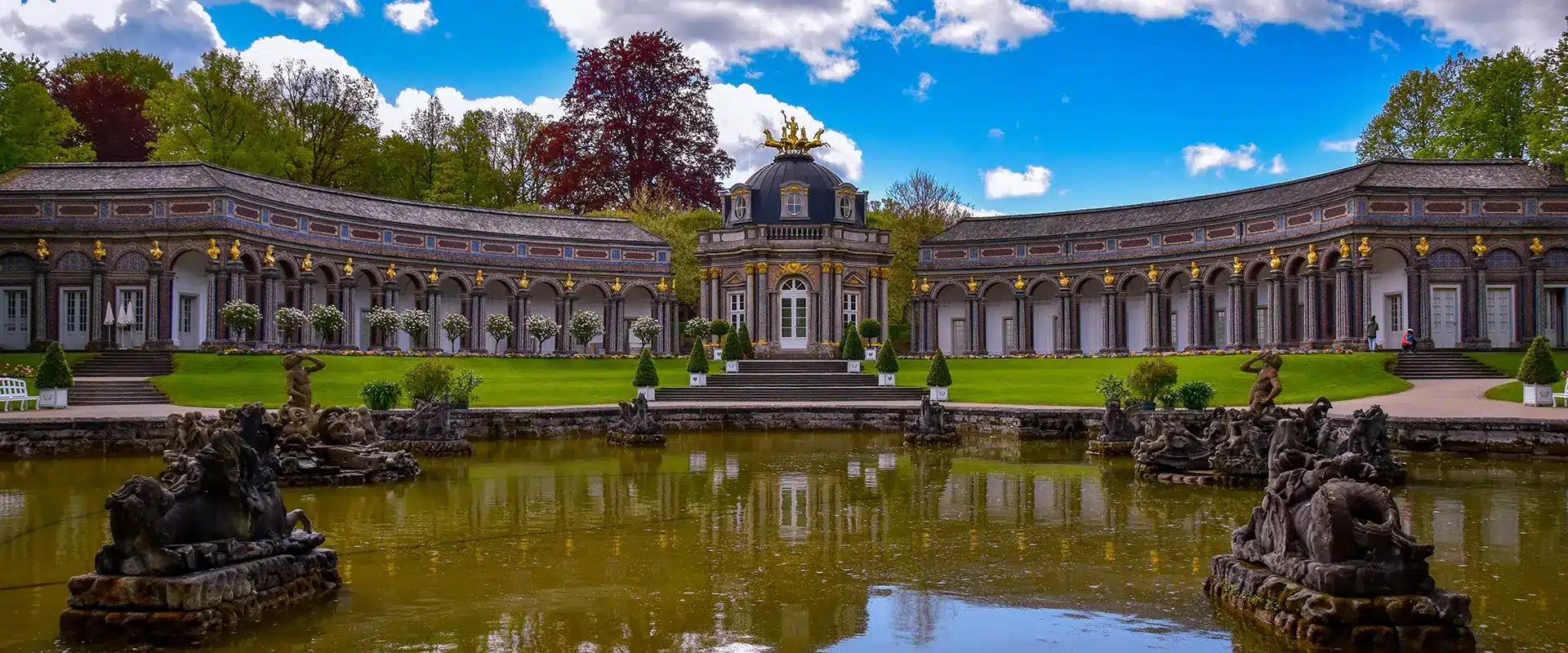 Blick auf das Schloss in der Erimitage mit dem Brunnen im Vordergrund