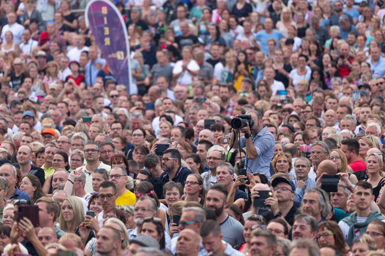 Ein Fotograf mit Kamera in einer Menschenmenge. | Foto: Florian Maßen