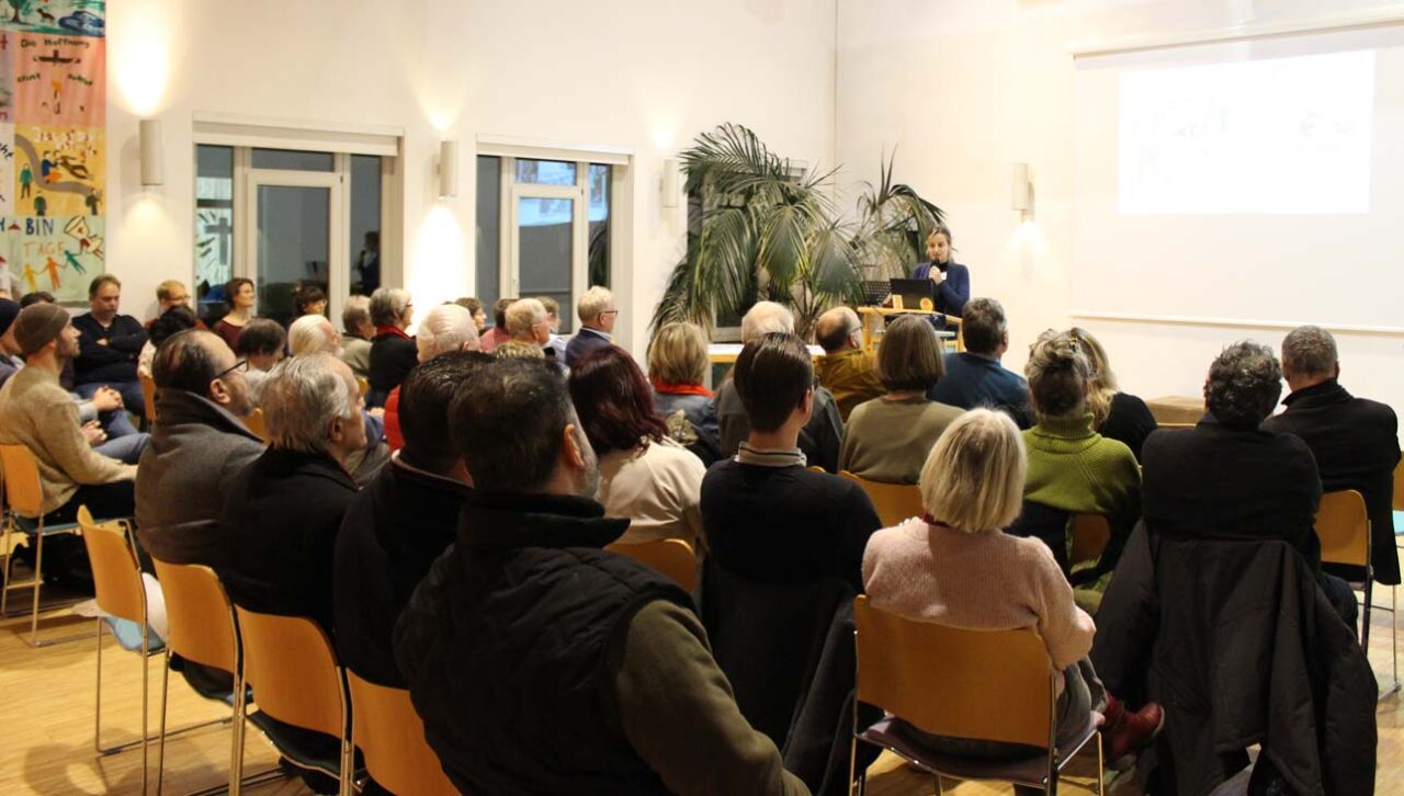 Eine Gruppe von Menschen sitzt auf Stühlen und hört einer Referentin zu. | Foto: Stadt Bayreuth